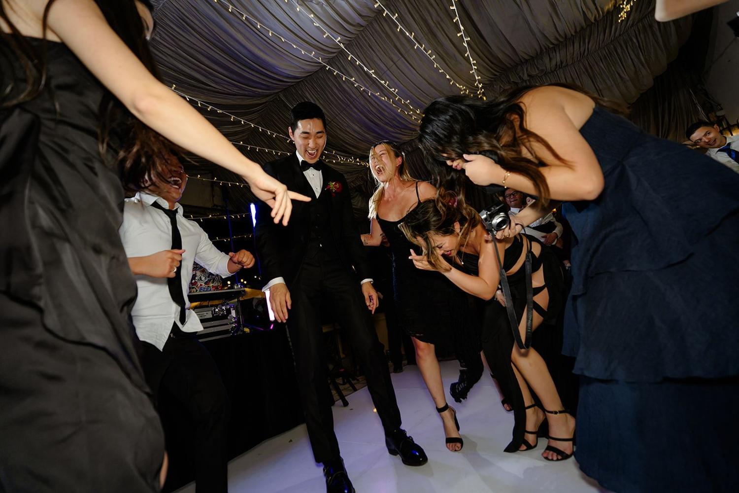 Guests dancing under a draped marquee
