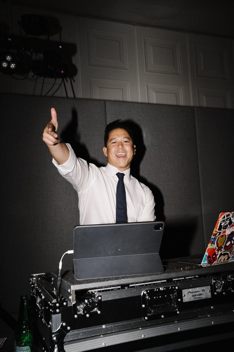 DJ FRNKIIE pointing to the crowd from behind his DJ booth