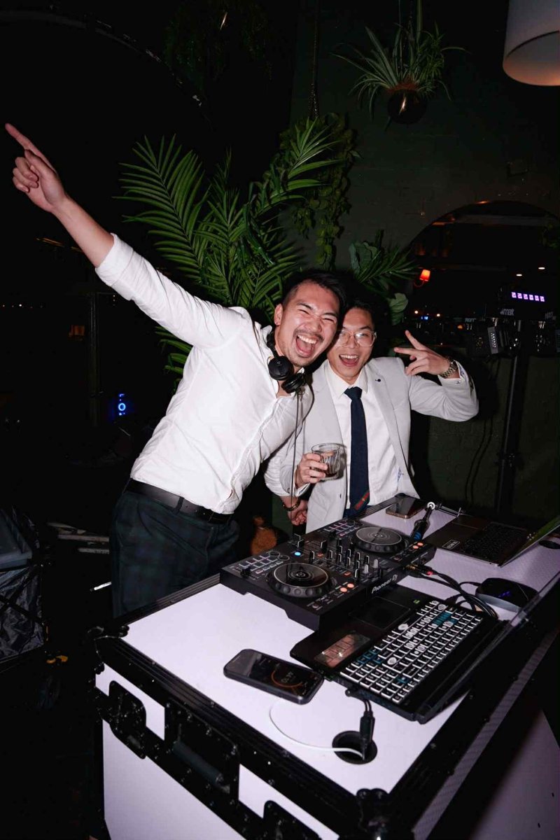 DJs Tandy and Tony celebrating behind the decks at a wedding
