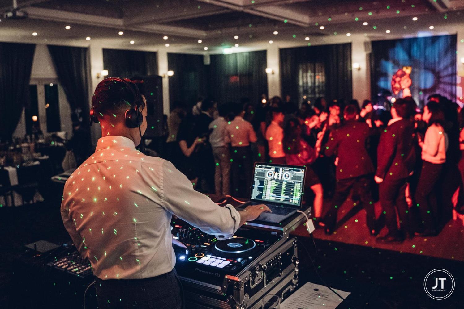 DJ FRNKIIE playing to a packed dance floor at a wedding reception